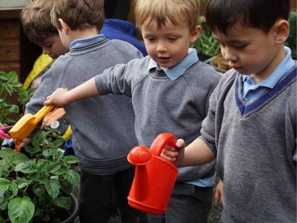 students holding a watering can