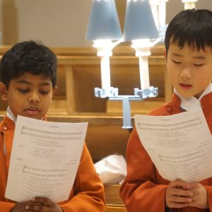 2 students reading from sheets